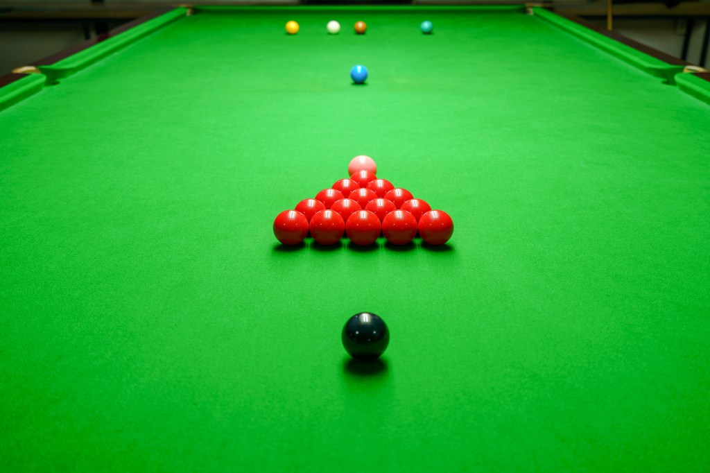 Professional snooker table set up inside an indoor arena ready for a match.