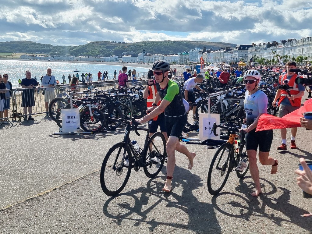Leading female sprint triathlete exiting transition and starting the cycling stage of the Llandudno triathlon.