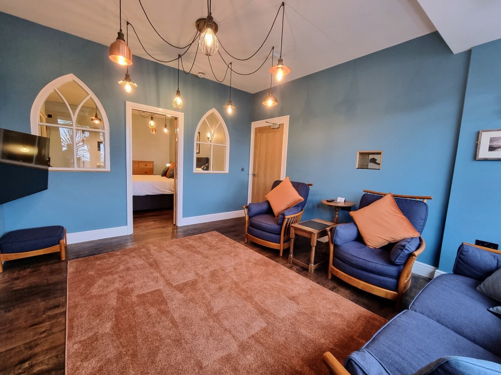 Lounge with view through doorway and arch windows into bedroom in Suite 101
