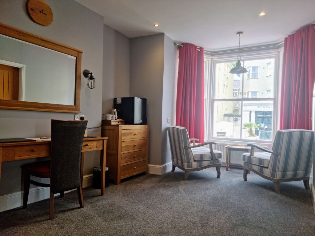 Dressing area in Room 103 with seating, storage space and natural light.